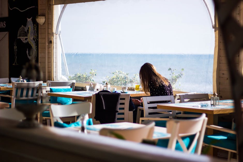 A serene indoor café with a view of the ocean, perfect for relaxation.